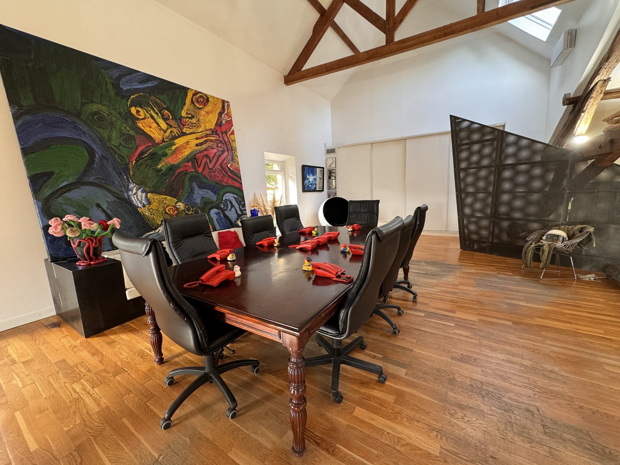 La salle de réunion sous la mezzanine, fauteuils noirs