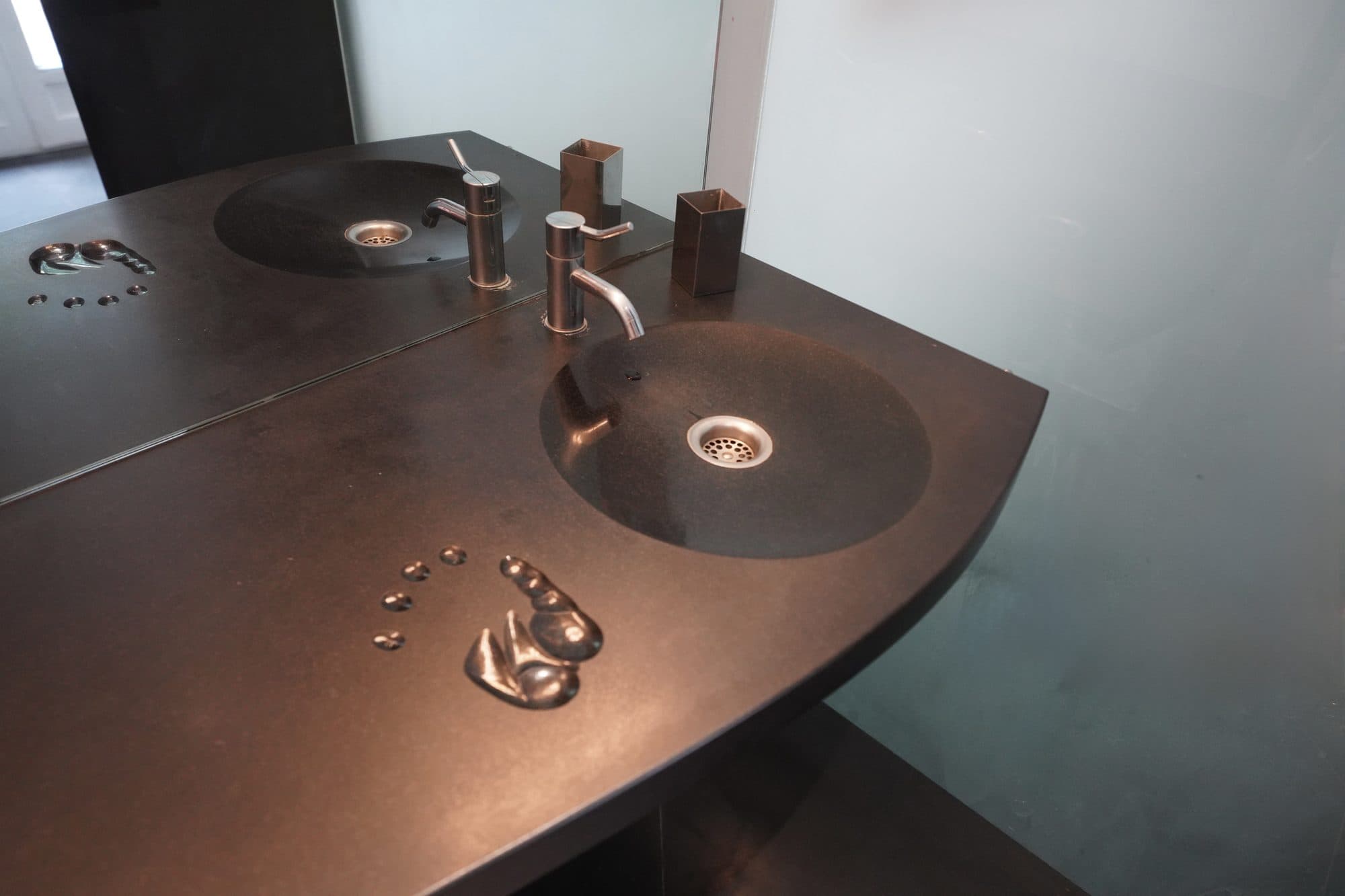 La salle de bain, vasque en pierre noire et empreintes gravées
