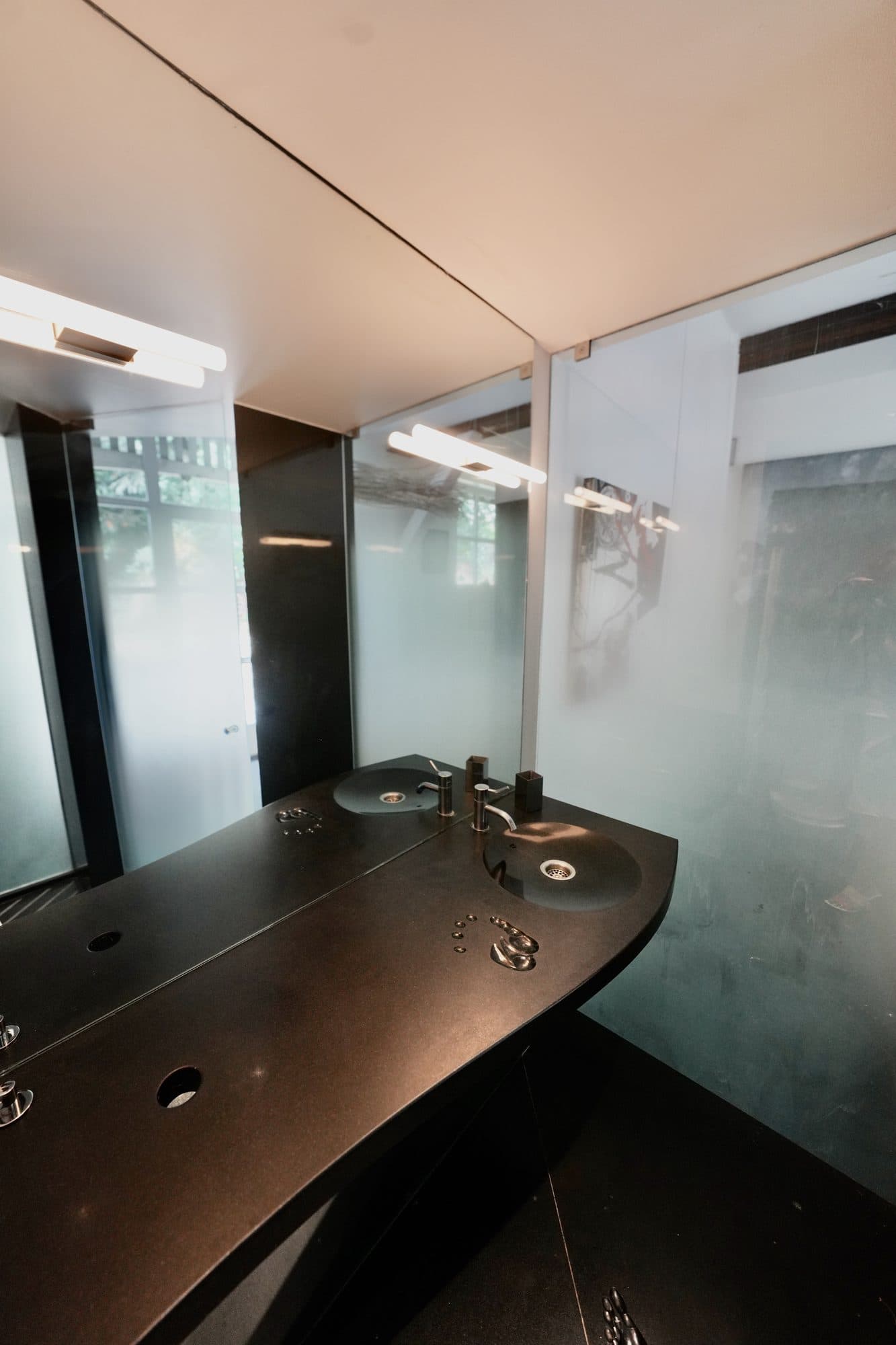 Le plan de toilette en pierre noire et le miroir
