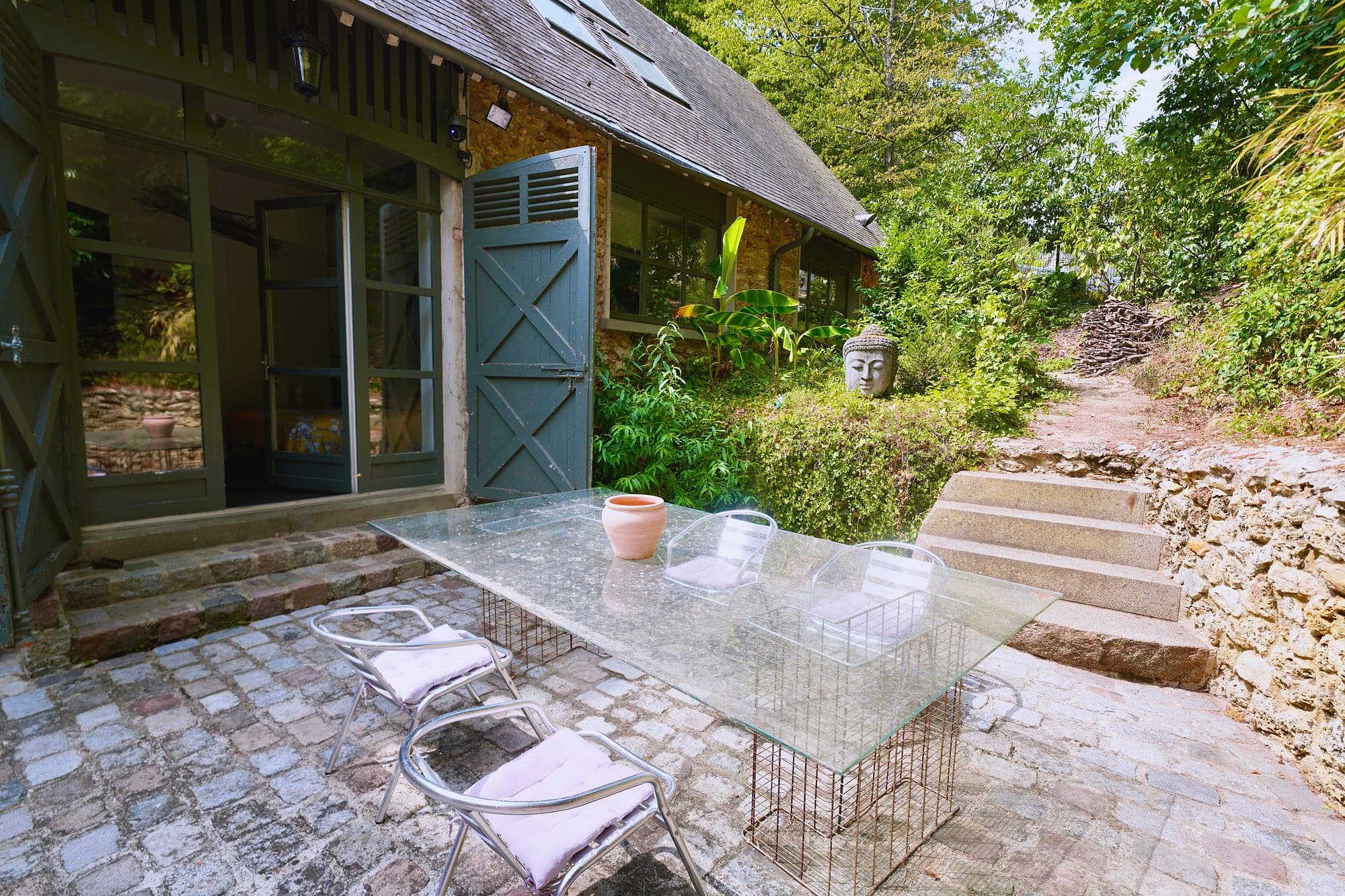 La cour privée, table en verre et mur de pierre
