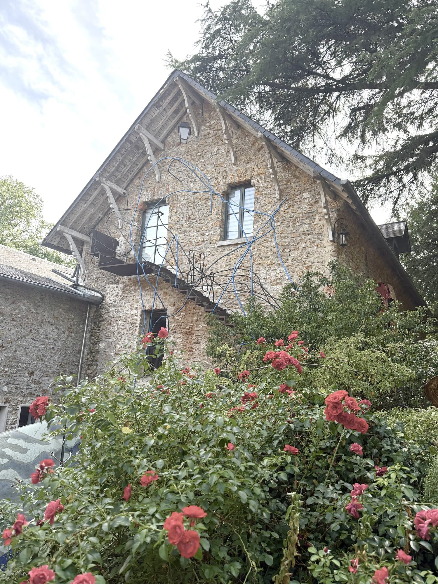 La façade en pierre du loft et ses rosiers