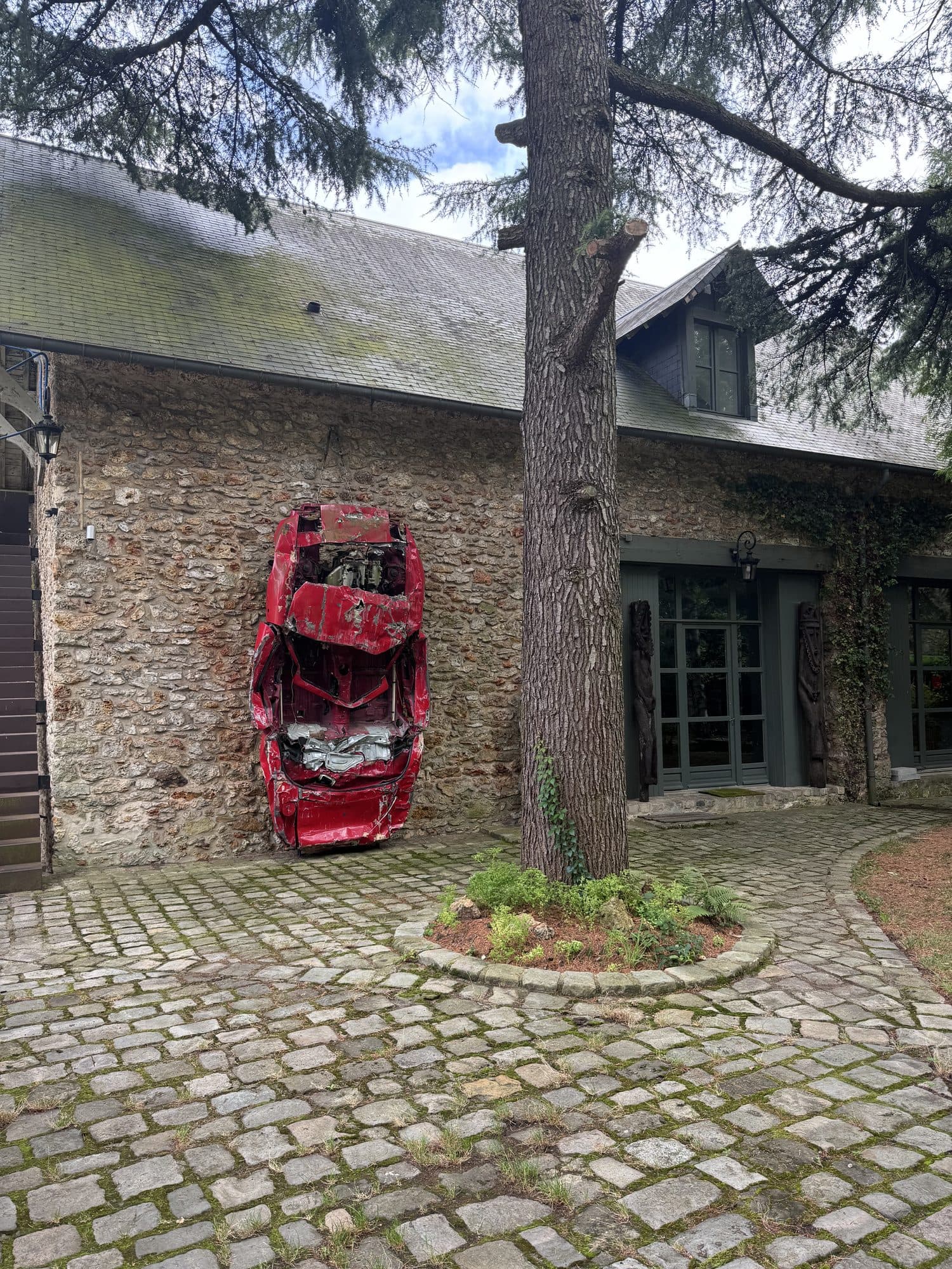 Le bâtiment du loft et la voiture compressée, œuvre accrochée au mur