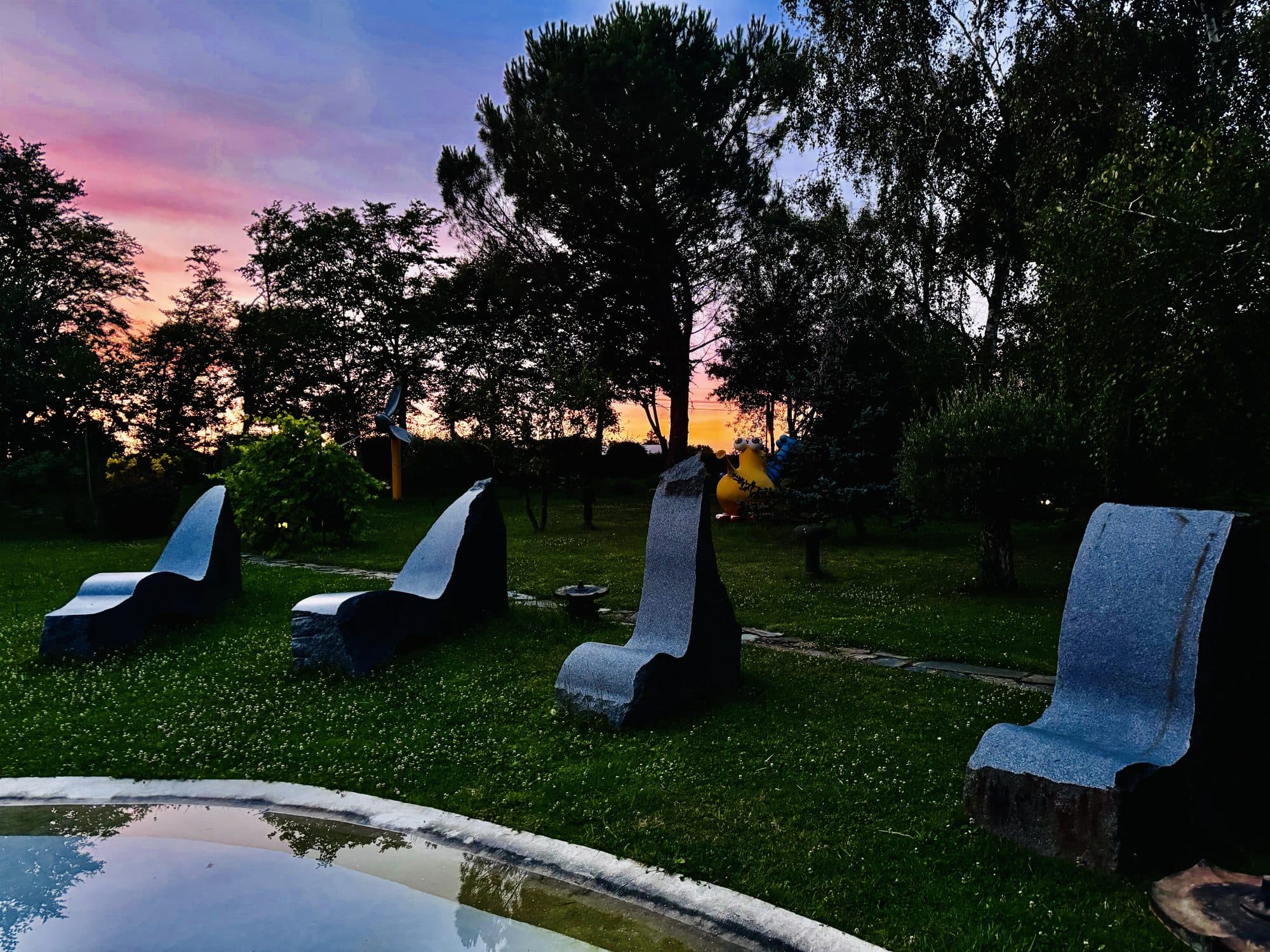 Coucher de soleil côté piscine, chaises longues de granit